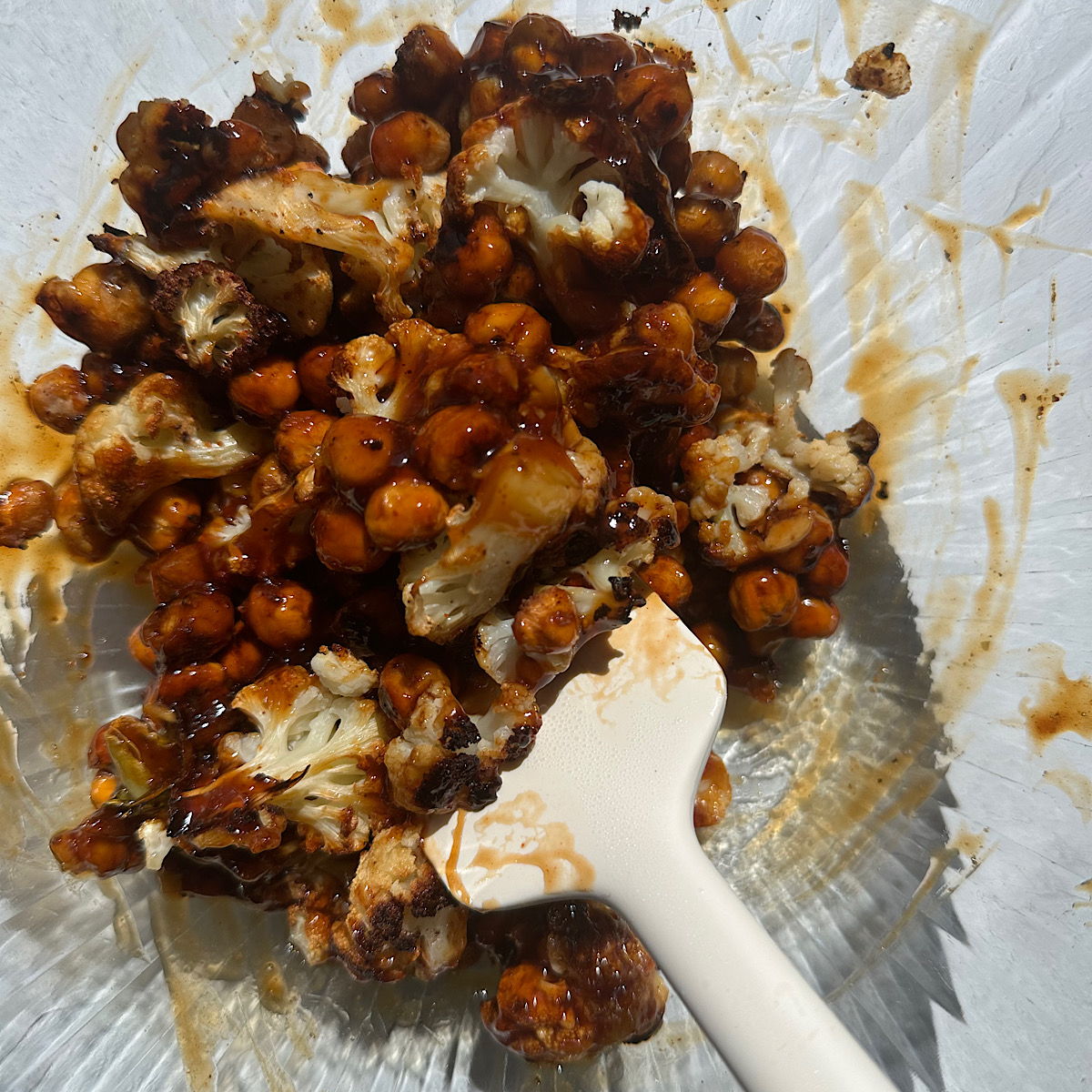 cauliflower and chickpeas in a bowl with hot honey sauce