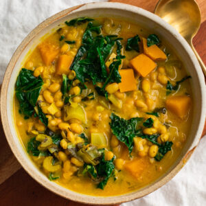 vegan golden harvest soup with leeks white beans kale and squash