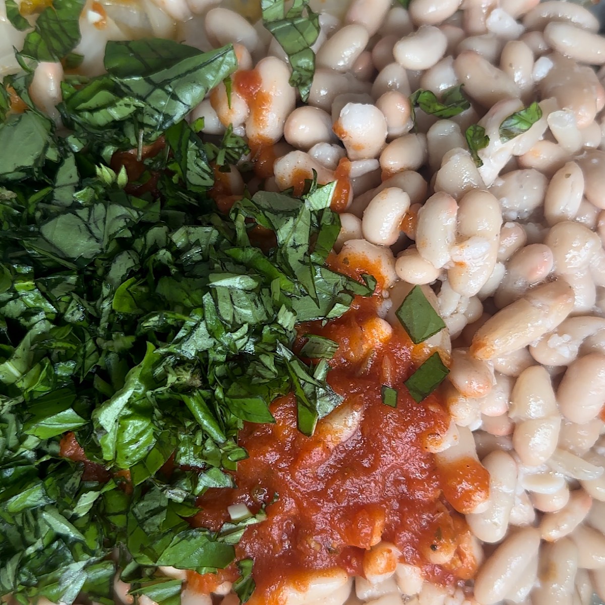 beans, sauce and basil in pan