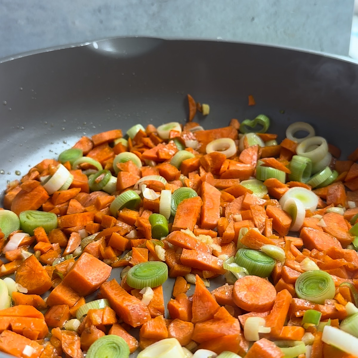 carrots, garlic and leeks in a skillet