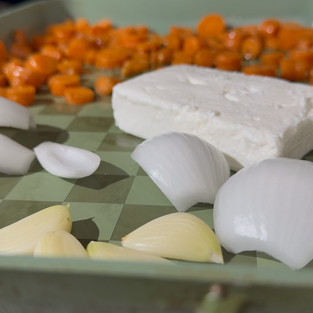 carrots onion and garlic baking on sheet pan